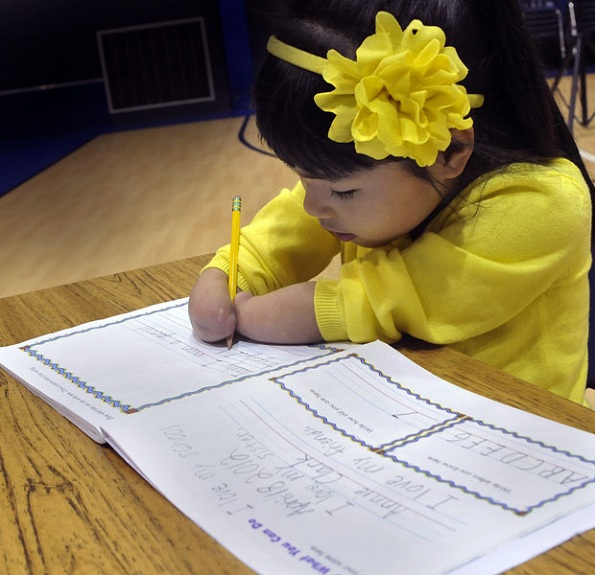 Determinada: Anne Clark, 7 anos, nasceu sem as mãos e ganhou o prêmio nacional de caligrafia nos EUA.