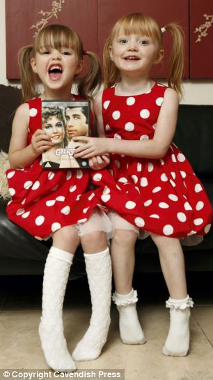 Gêmeas Isabella e Gabriella com DVD do filme que elas mais gostam de dançar (Imagem: Daily Mail)