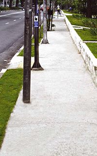 Calçada em concreto em frente a uma praça: nesse caso, a faixa de acesso é dispensável.