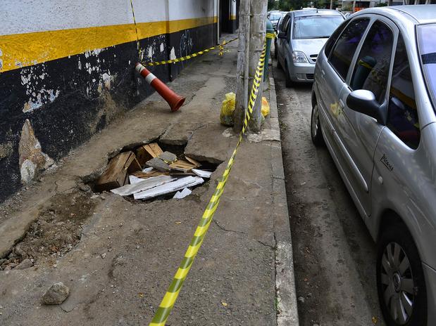 Na rua Cancioneiro Popular, um buraco provocou a interdição de parte de uma calçada. Foto: Fernando Borges / Terra