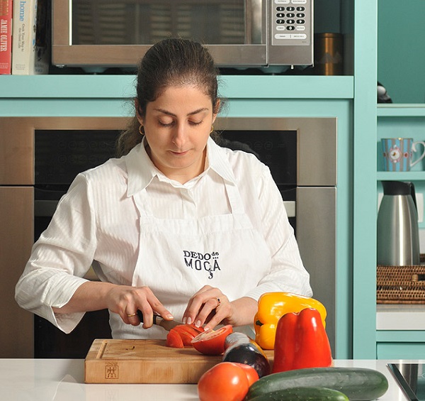 A musicoterapeuta Helena D'Angelo manipula alimentos na cozinha Dedo de Moça, em São Paulo
