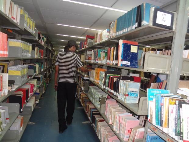 O estudante universitário percorre os corredores da biblioteca central da UFPA, que não dispõe de livros didáticos transcritos em braile para pessoas com deficiência visual. (Foto: Luana Laboissiere/G1)