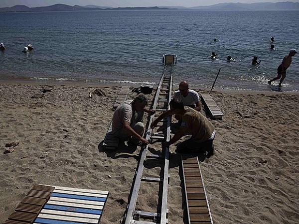 Trio trabalha na instalação do Seatrac em Nea Makri, a leste de Atenas (Foto: Yorgos Karahalis/Reuters)