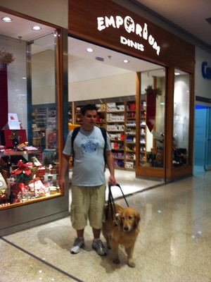 O analista de sistemas Gabriel Vicalvi e sua cão-guia, a golden retriever Julia, logo após sair da loja. Segundo ele, um funcionário o expulsou do estabelecimento por estar com um cachorro (Foto: Arquivo pessoal)