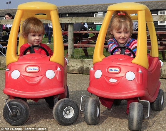 Charlotte e Ellie brrincando com carros de brinquedo.