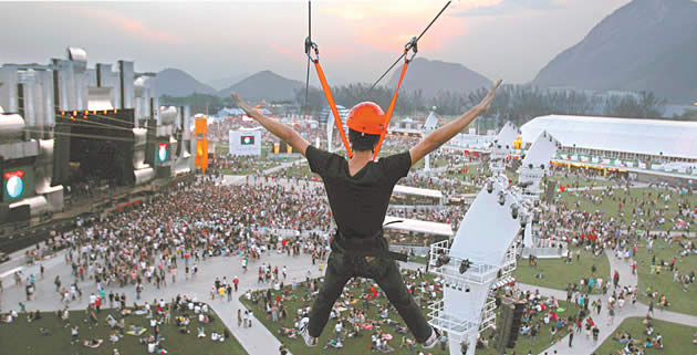 Jovem se diverte num ‘rasante’ de tirolesa sobre o Rock in Rio | Foto: Antonio Lacerda / EFE