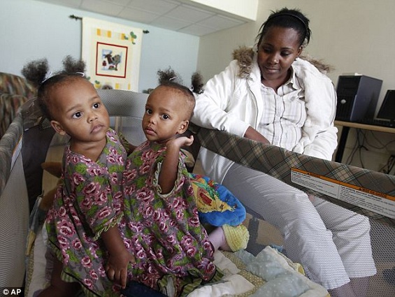 Antes da cirurgia: Lisandra Sanatis, 24, senta-se com as filhas Maria (esquerda) e Teresa (direita) antes de serem separadas.