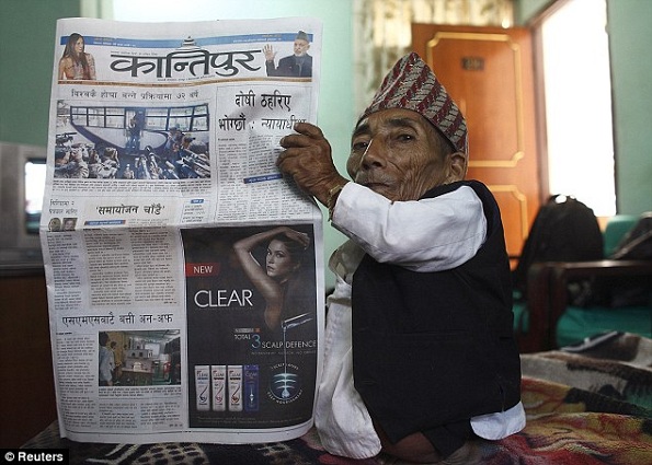 Chandra Bahadur Dangi, 72, posa com um jornal local para mostrar seu corpo minúsculo.