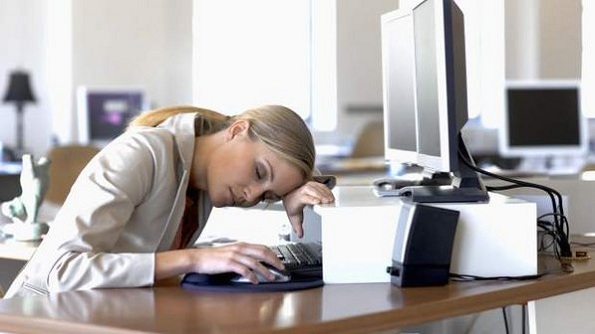 Imagem de uma mulher dormindo em frente ao computador