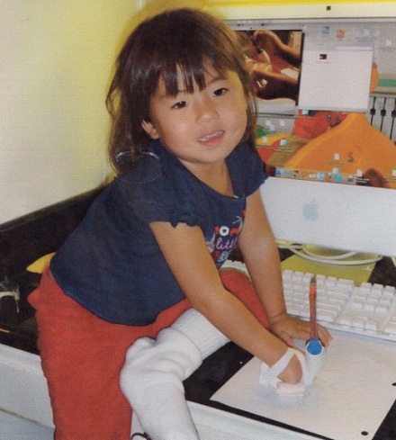 A pequena Danielle Fairchild orgulhosa por poder usar o lápis pela primeira vez.