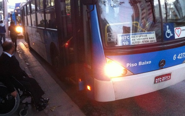 Giovani Batista aguarda ajuda de motorista para entrar em ônibus parcialmente adaptado