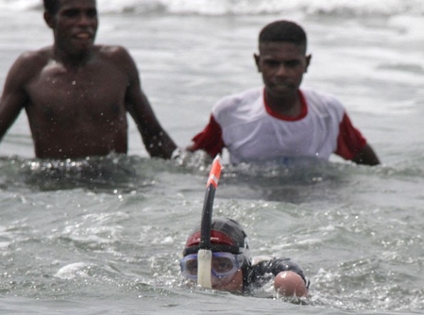 O nadador amputado é visto chegando á costa da ilha na Indonésia (Foto: Levi Cunding/AFP)