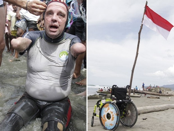 Croizon descansa após chegar a terra firme. à direita, sua cadeira de rodas é vista adornada com uma bandeira da Indonésia (Foto: Levi Cunding/AFP)