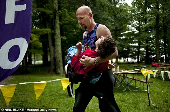 Devoção: Rick van Beek, 39, leva a sua filha Maddy, que tem paralisia cerebral, durante uma corrida de triathlon. Eles participaram de mais de 70 eventos. Maddy adora o ar livre (Foto Reprodução: Daily Mail)