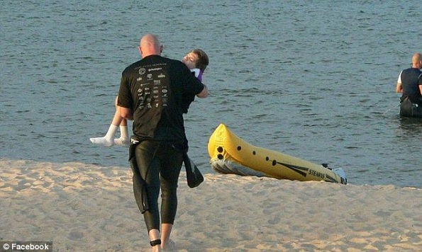 Van Beek se aproximando da água, carregando Maddy, para participar da modalidade natação. (Foto Reprodução: Daily Mail)