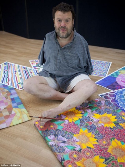 Tom Yendell, que nasceu sem os braços devido ao medicamento Talidomida, tornou-se um artista de renome mundial em  pintura com a boca e os pés. (Imagem: Daily Mail)