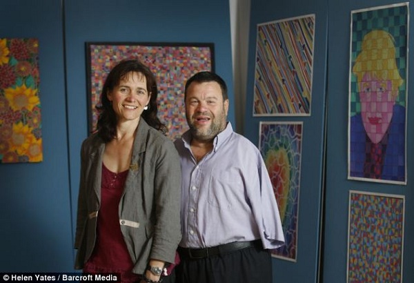  Yendell na foto com sua esposa Lucy e uma amostra do seu trabalho. Diz que às vezes ele fica com cólicas ou dor muscular quando pinta durante muito tempo (Imagem: Daily Mail)