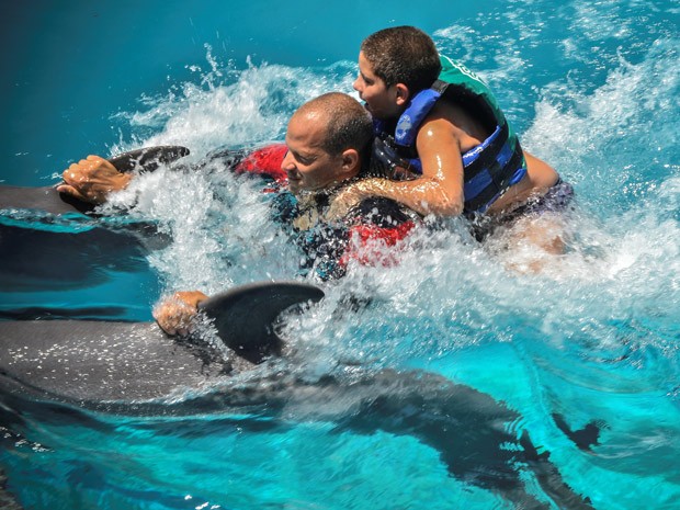 Adrian e Javier 'surfam' em golfinhos (Foto: AFP Photo/Adalberto Roque)