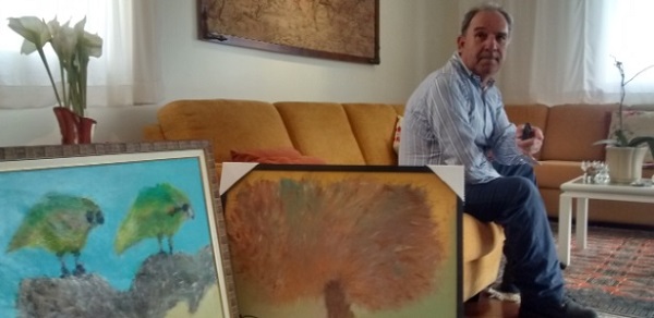Osmar Santos ao lado de seus quadros em sua casa no centro de São Paulo