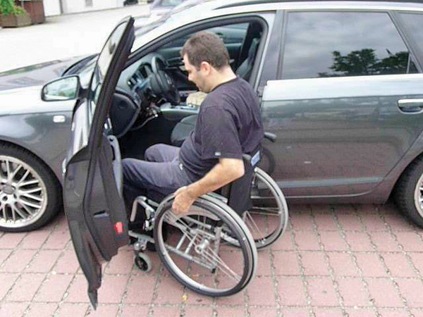 Homem cadeirante entrando no carro.