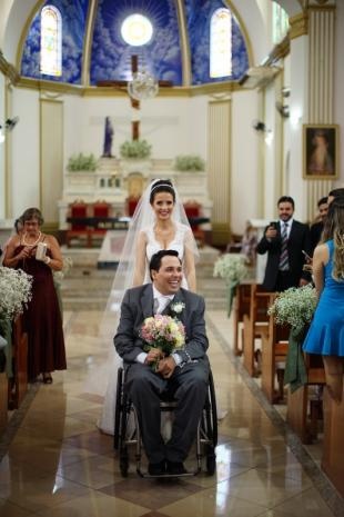Na saída da igreja, ela empurrava cadeira enquanto noivo segurava buquê. (Foto: Eurides Aoki)