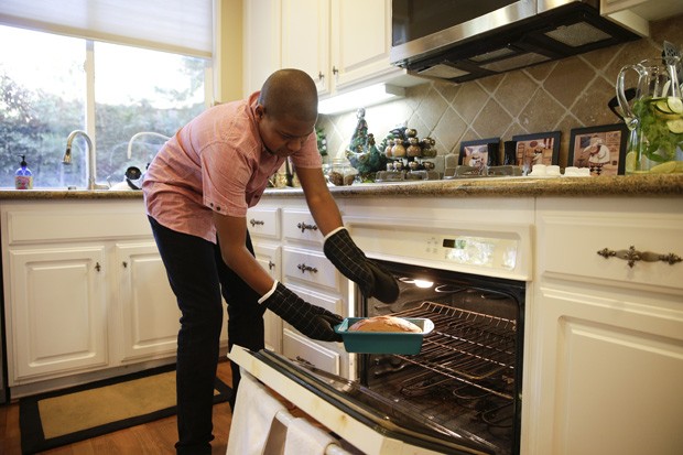 O adolescente autista Chase Bailey, de 13 anos, tira bolo do forno: garoto tem programa de culinária no YouTube (Foto: AP Photo/Jae C. Hong)